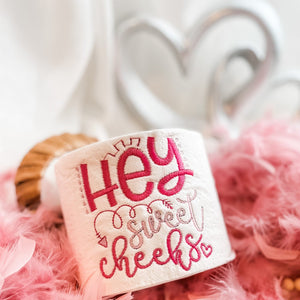 hey sweet cheeks embroidered on a roll of toilet paper in pink thread